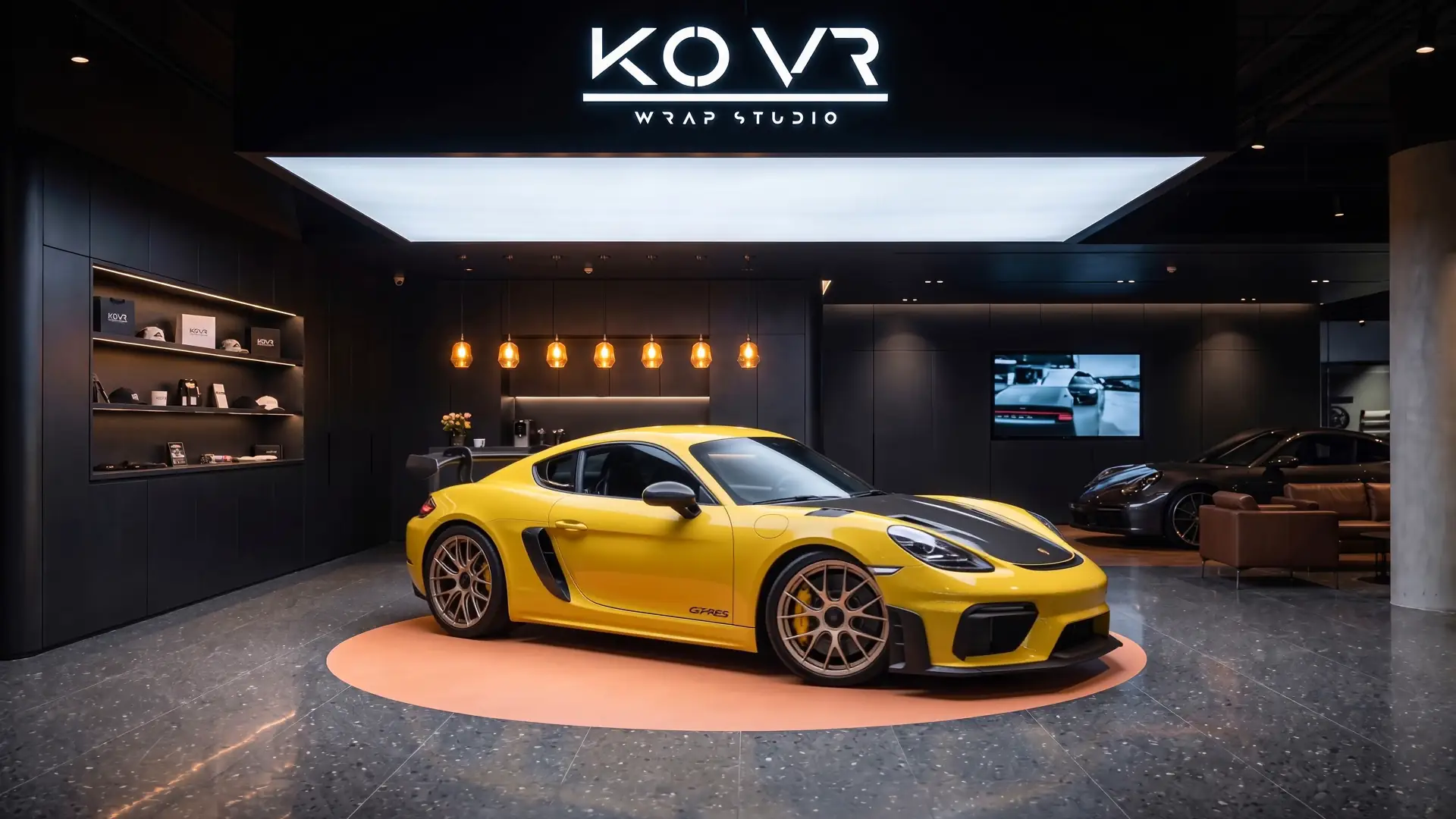Matte yellow vehicle beside the studio's branded wall displays